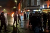 La police sécurise les lieux à Dublin après qu'une voiture de police a été incendiée lors de heurts faisant suite à une attaque au couteau le 23 novembre 2023 à Dublin