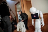 La Japonaise Kimiko Nishimoto chez elle avec son fils Kazutami et son robot androïd Pepper (d), le 16 janvier 2017 à Kumamoto