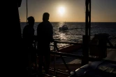 Deux migrants regardent le soleil se lever sur le pont du Sea Watch le 31 janvier 2019