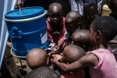 Des enfants se lavent les mains, à des fontaines installées dans le bidonville de Kibera, à Nairobi, pour combattre l'épidémie du coronavirus, le 18 mars 2020 