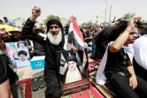 Des partisans bradissent des portraits du chef chiite Moqtada Sadr après la prière du vendredi, le 12 août 2022 à Bagdad 