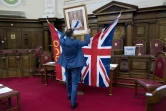 L'officier d'Etat civil d'Islington, Dion Goncalves, installe un portrait de la reine Elizabeth II avant une cérémonie d'allégeance de nouveaux citoyens britanniques, le 5 février 2018