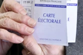 Une femme montre sa carte d'électrice au premier tour de la primaire élargie du PS à Nantes le 22 janvier 2017