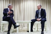 Le président russe Vladimir Poutine (d.) écoute le président du CIO Thomas Bach (g.) lors de leur rencontre aux Jeux européens de 2019 à Minsk, le 30 juin 2019