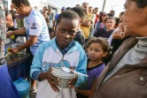 Des migrants vénézuéliens qui ont fui la crise économique dans leur pays reçoivent de l'aide et de la nourriture à Tumbes, au Pérou, à la frontière avec l'Equateur, le 23 août 2018
