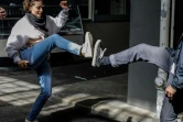 Deux jeunes gens se saluent avec les pieds, selon un geste connu sous le nom de "salut à la mode Wuhan", à Berlin le 20 avril 2020