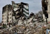 Des pompiers dans les décombres d'immeubles détruits par un bombardement russe, le 8 avril 2022 à Borodianka, au nord-ouest de Kiev, en Ukraine