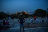 Des Athéniens contemplent, le 17 mai au soir, l'Acropole fermé depuis le début du confinement et qui devaient rouvrir le lendemain matin
