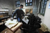 Un employé utilise une machine imprimant des caractères de plomb frappés de signes hiéroglyphes dans l'atelier typographique de l'Institut français d'archéologie orientale, le 10 décembre 2020 au Caire