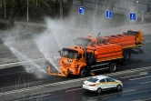 Un véhicule municipal désinfecte une route en banlieue de Moscou, le 28 mars 2020