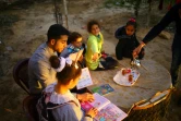 Mosaab Abou Toha (G) lit des livres à des enfants dans le jardin d'une maison de Beit Lahya dans le nord de Gaza le 20 février 2017