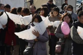 Des Japonais se recueillent avant un lâcher de ballons le 11 mars 2017 à Natori