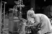 Photo d'archive datée des années cinquante d'un client observant les articles d'un brocanteur au marché aux Puces de Saint-Ouen