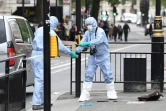 Des officiers de la police scientifique avec un couteau confisqué à un homme qui a été arrêté près du Parlement de Westminster à Londres, le 27 avril 2017