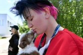 Une bénévole de la fondation américaine Clean Cultures Fund (CFF) tient un chiot dans ses bras, devant un hôpital pour chiens errants près de centrale nucléaire de Tchernobyl, le 8 juin 2018 en Ukraine