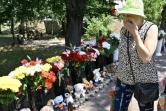 Femme devant le mémorial fait de fleurs et de peluches, le 29 juin 2022, devant le centre commercial de Krementchouk bombardé deux jours plus tôt