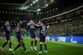 La joie du milieu de terrain portugais de Manchester City Bernardo Silva, félicité par ses coéquipiers, après avoir marqué le 4e but contre le Sporting Portugal, lors de leur 8e de finale aller de la Ligue des Champions, le 15 février 2022 à Lisbonne