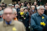 Des personnes rassemblées devant le monument aux Héros du Ghetto, des jonquilles à la main, le 19 avril 2016 à Varsovie
