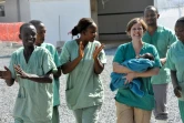 La petite Noubia dans les bras d'une soignante le 28 novembre 2015 à Conakry quelques jours après avoir été déclarée guérie du virus Ebola