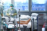 Des soignants aident un patient atteint du Covid-19 dans une chambre de l'unité de soins intensifs Covid-19 de l'hôpital universitaire de Bochum, dans l'ouest de l'Allemagne, le 16 décembre 2021