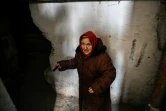 Une femme âgée descend dans la cave de son immeuble à la lueur d'une lampe torche pour se protéger des bombardements à Chtchastian près de Lougansk, en Ukraine, le 22 février 2022