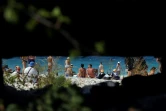 Des touristes sur une plage de l'île de Sazan, en Albanie, vus depuis la meurtrière d'un ancien bunker, le 30 juillet 2024