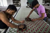 Des employés impriment à la planche une étoffe de la créatrice Brigitte Singh, le 2 juin 2022 dans son atelier d'Amber, dans l'Etat du Rajasthan, en Inde