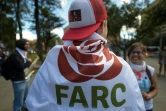 Un militant des Farc enveloppé dans un drapeau avec un logo du nouveau parti politique "révolutionnaire" à Bogota, le 1er septembre 2017