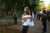 Des habitants devant un immeuble partiellement détruit par une attaque meurtrière de drones à Soumy en Ukraine le 3 juillet 2023
