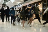 Des manifestants courent dans un centre commercial dans le quartier de Tai Po, le 26 décembre 2019 à Hong Kong