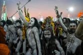 Des ascètes hindous couverts de cendres marchent en procession après avoir pris un bain au confluent des fleuves sacrés du nord de l'Inde durant le festival Kumbh Mela à Allahabad le 15 janvier 2019