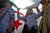 Des Algériennes sous un grand drapeau du pays lors de la manifestation d'enseignants et d'élèves contre l'extension du quatrième mandat d'Abdelaziz Bouteflika, le 13 mars 2019 à Alger