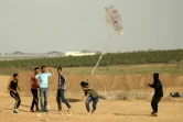 Des jeunes Palestiniens tentent de faire s'envoler un cerf-volant auquel est attaché un cocktail Molotov, le 18 avril 2018 près de la frontière entre la bande de Gaza et Israël