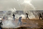 Des Palestiniens fuient les gaz lacrymogènes tirés par les soldats israéliens lors de protestations à la frontière entre Israël et la bande de Gaza, le 13 avril 2018