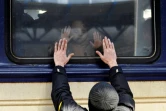 Un homme fait ses adieux à sa famille en partance à bord d'un train d'évacuation, le 4 mars 2022 en gare de Kiev