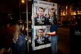 Des sympathisants de LREM collent des affiches de campagne d'Emmanuel Macron, à Vanves, en région parisienne, le 16 mars 2022