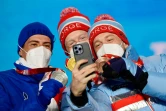 Le Français Quentin Fillon Maillet et les Norvégiens Johannes et Tarjei sur le podium du sprint de biathlon des JO de Pékin, le 14 février 2022