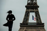 Une femme masquée devant la tour Eiffel, le 11 mai 2020 à Paris