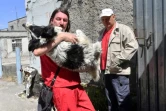 Un bénévole de la fondation américaine Clean Cultures Fund (CFF) porte un chien dans ses bras, le 8 juin 2018 près de la centrale nucléaire de Tchernobyl, en Ukraine