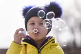 Un enfant ukrainien fait des bulles de savon après avoir traversé la frontière ukraino-roumaine à Siret, dans le nord de la Roumanie, le 20 mars 2022