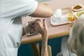 Une aide-soignante aide une patiente à manger à l'hôpital d'Argenteuil, le 23 juillet 2013