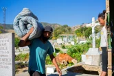 Un Vénézuélien porte un matelas dans le cimetière de Caracas où il réside, le 10 février 2021