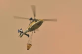 Un hélicoptère va larguer une charge d'eau sur un feu de forêt à Bargo, le 21 décembre 2019 en Australie