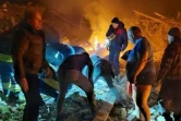 Photo transmise par les autorités ukrainiennes le 1er mars 2022 montrant les secours en train de porter secours aux victimes du bombardement russe sur Jytomyr, à l'ouest de Kiev 