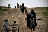 Face à une butte qu'il faut gravir pour rentrer dans Mossoul, la famille de Samir Hamed se saisit de petites charrettes en fer, abandonnées par des habitants qui ont fui la ville, le 17 mars 2017