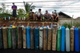 Des gens attendent pour remplir des bouteilles d'oxygène pour leurs proches atteints de Covid-19, à Mandalay le 13 juillet 2021