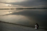 Une femme ramasse des ordures recyclables près du Pont de l'Amitiés sur le fleuve Yalu, à Dandong, le 5 juillet 2017