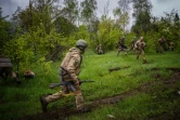 Des soldats ukrainiens courent pour se mettre à couvert de tirs d'artillerie sur la ligne de front, près de la ville de Bakhmout, en Ukraine, le 30 avril 2023