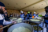Des membres du club de motards "Hope Bikers Syria" préparent des repas pour l'iftar qu'ils vont distribuer à des personnes dans le besoin, pendant le ramadan, le 25 mars 2024 à Damas, en Syrie