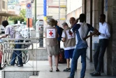 Des membres de le Croix-Rouge monégasque avec des migrants le 14 juin 2018 à la gare de Vintimille, dans le nord de l'Italie, à proximité de la frontière avec la France